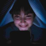Teen Using Phone in Blanket
